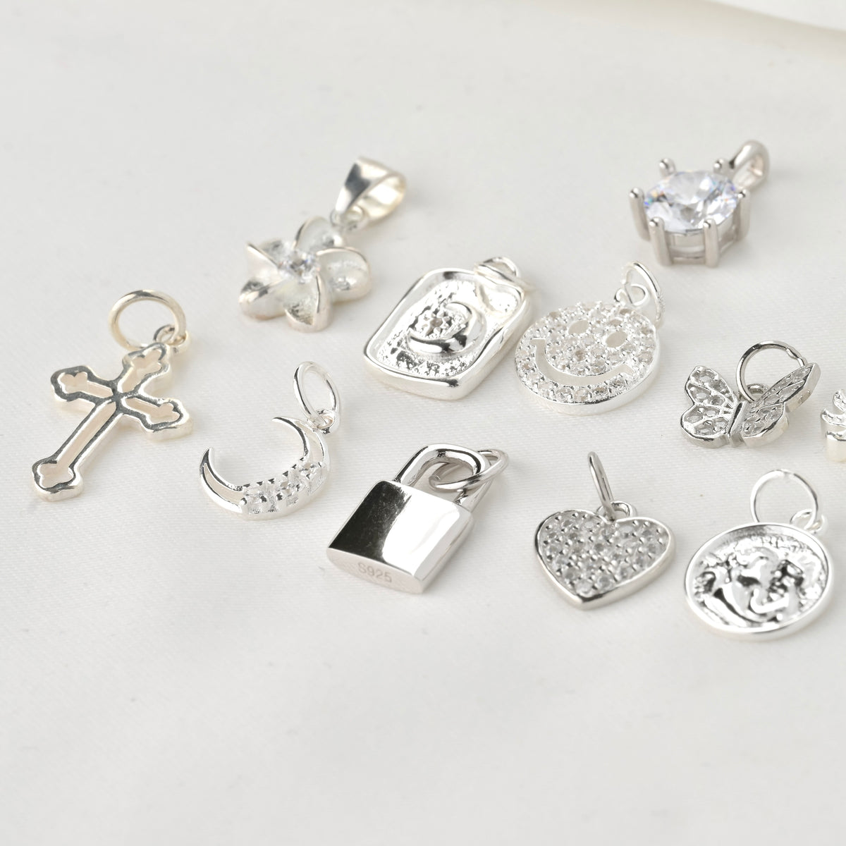 Collection of various silver pendants on a light background