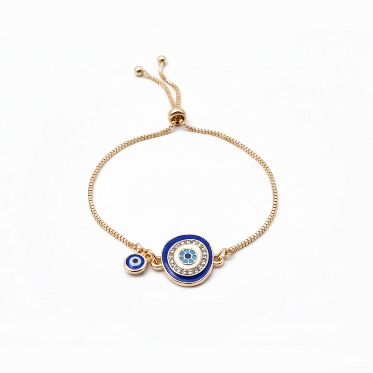 Gold slider bracelet with blue evil eye charms on a white background