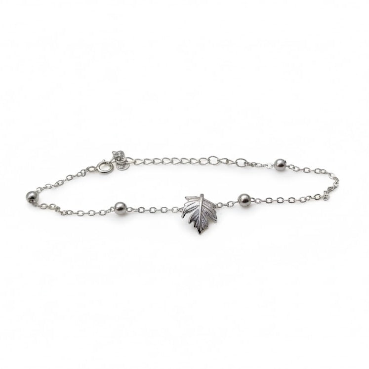 Silver maple leaf charm braceleton a white background