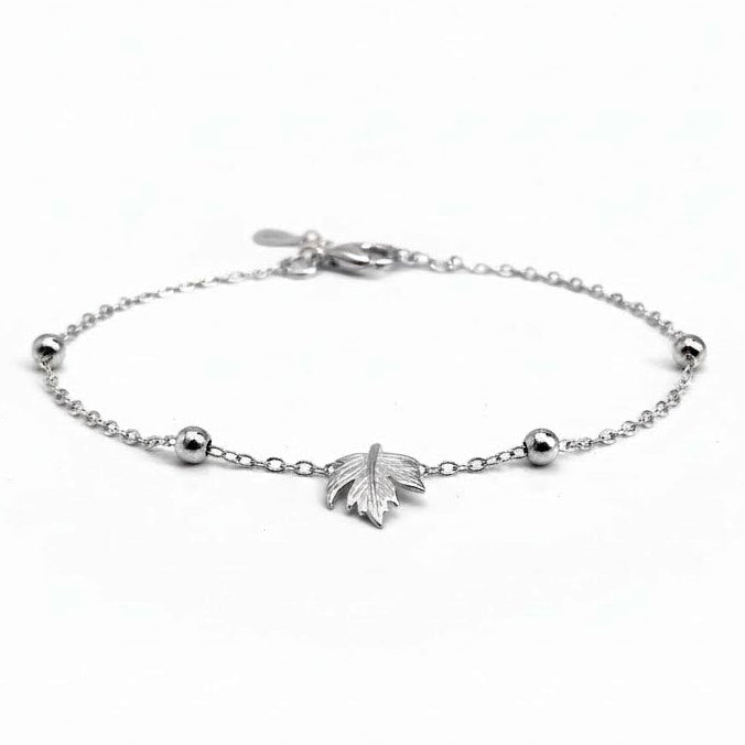 Silver maple leaf bracelet with a beaded chain on a white background