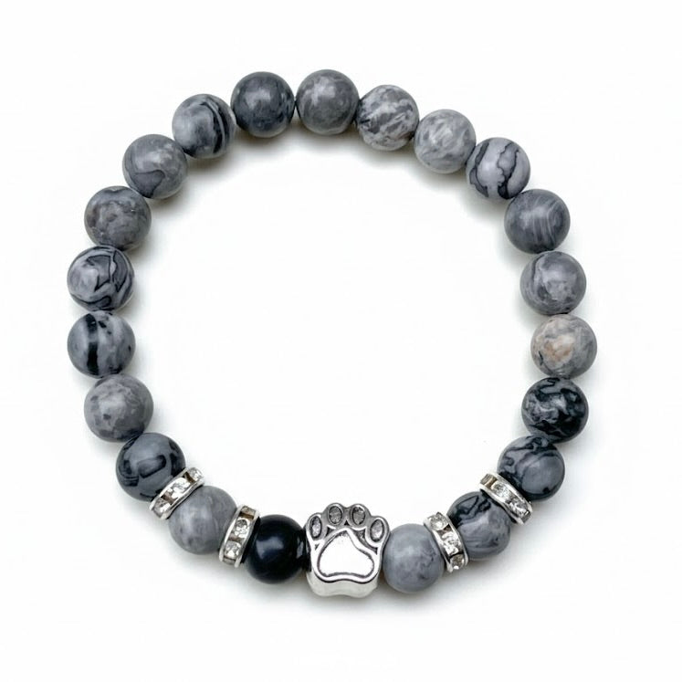 Gray marbled beaded bracelet with a paw charm on a white background