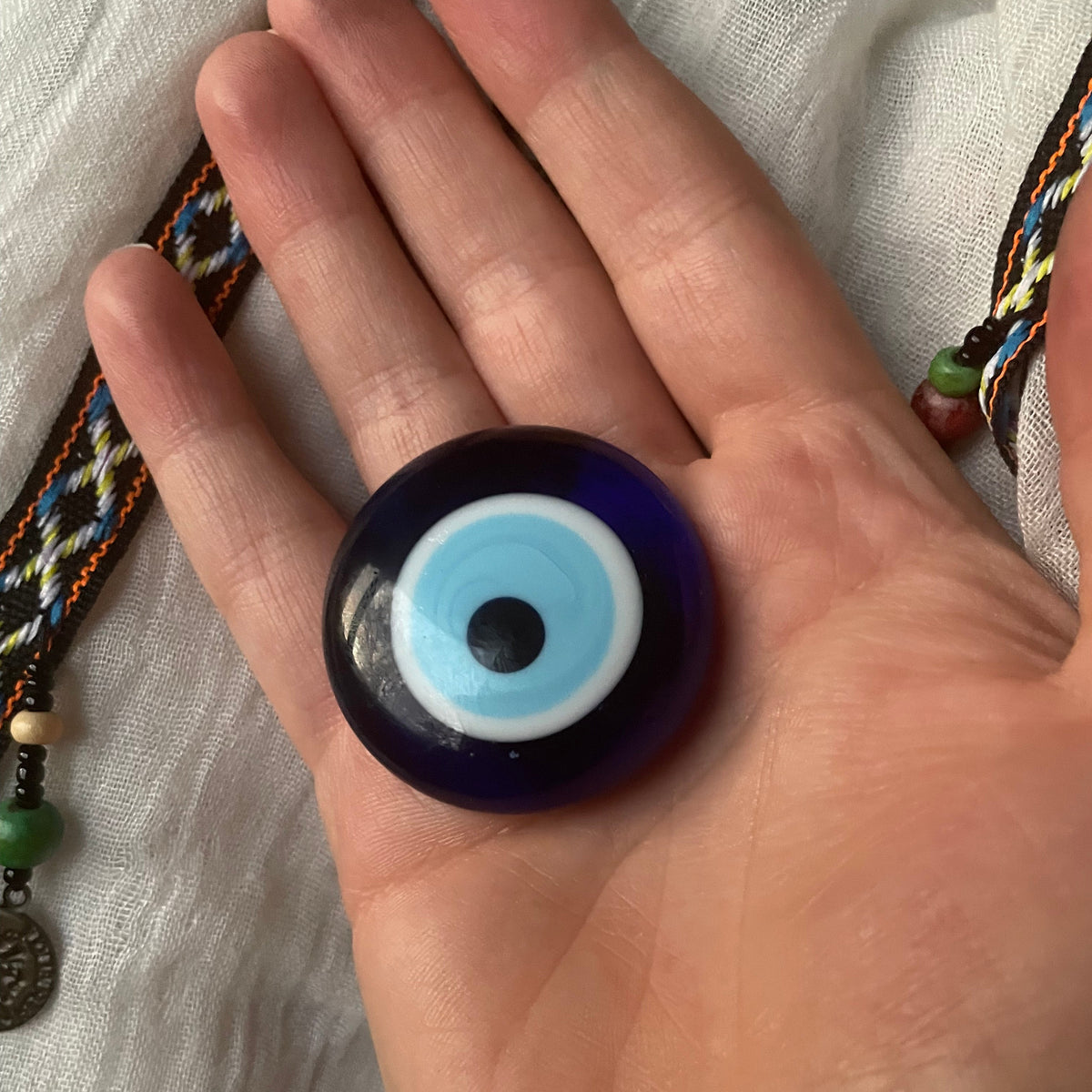 Round evil eye magnet held in hand