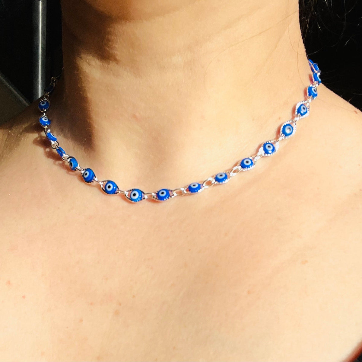 Necklace with blue and silver beads worn by a person