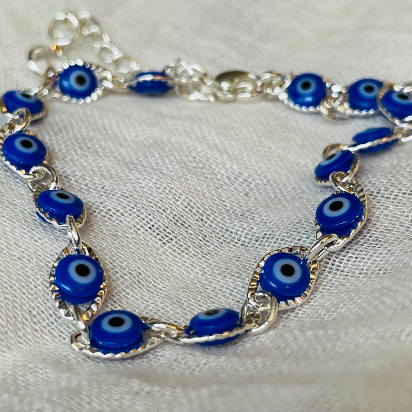 Beaded evil eye bracelet on a white fabric background