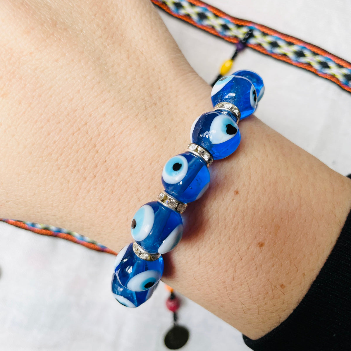 Oversized light blue beaded bracelet with silver accents on a wrist against a white background