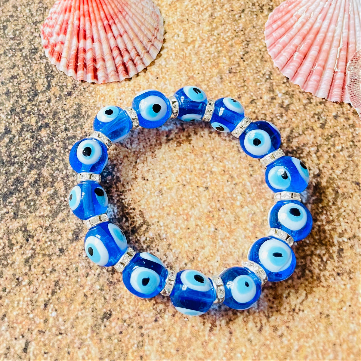 Light blue beaded bracelet on sand with shells and starfish
