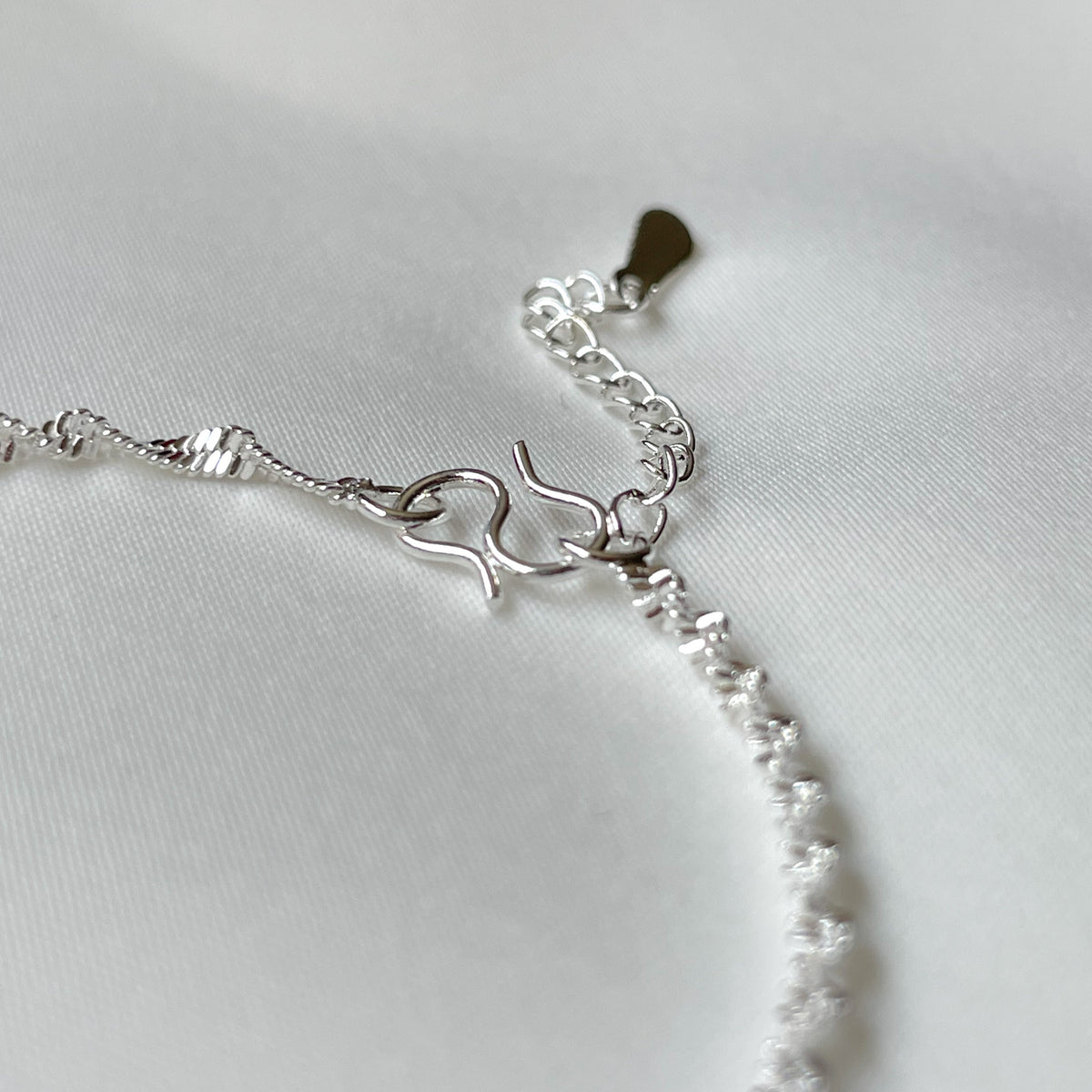 Close p view of the S hook clasp and extender chain of the twisted chain bracelet