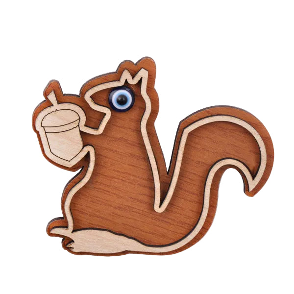 Wooden squirrel fridge magnet with a nut on a white background