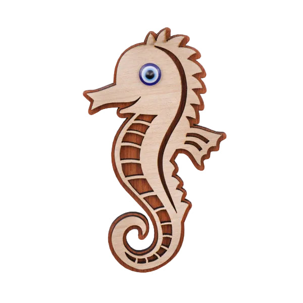 Wooden seahorse magnet with an evil eye detail on a white background