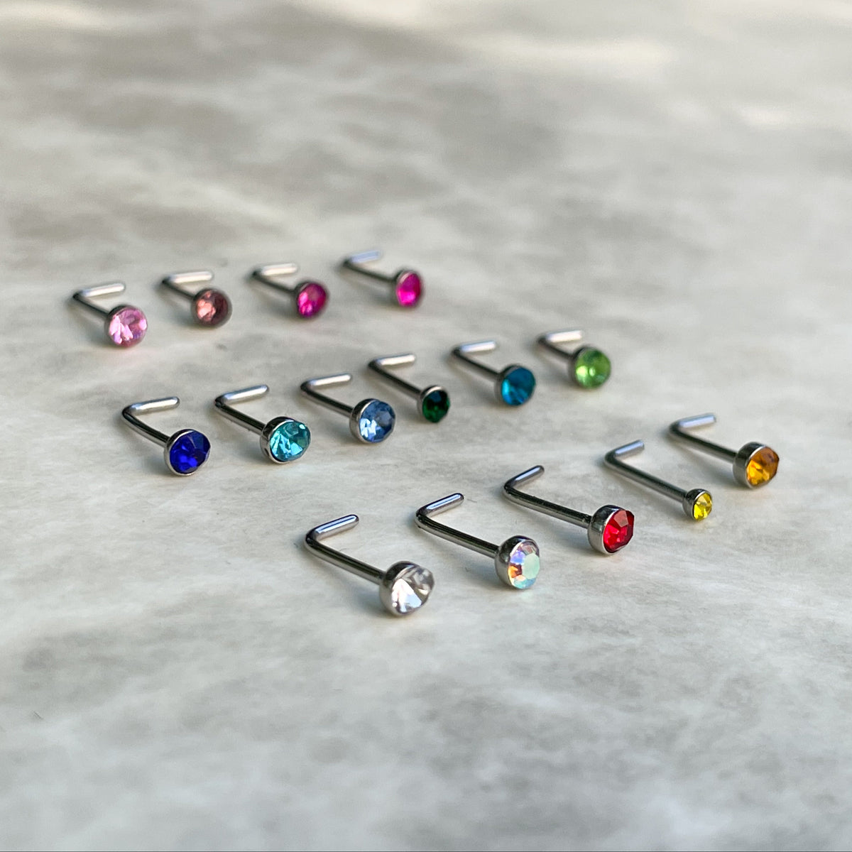 Set of colorful nose studs on a marble surface
