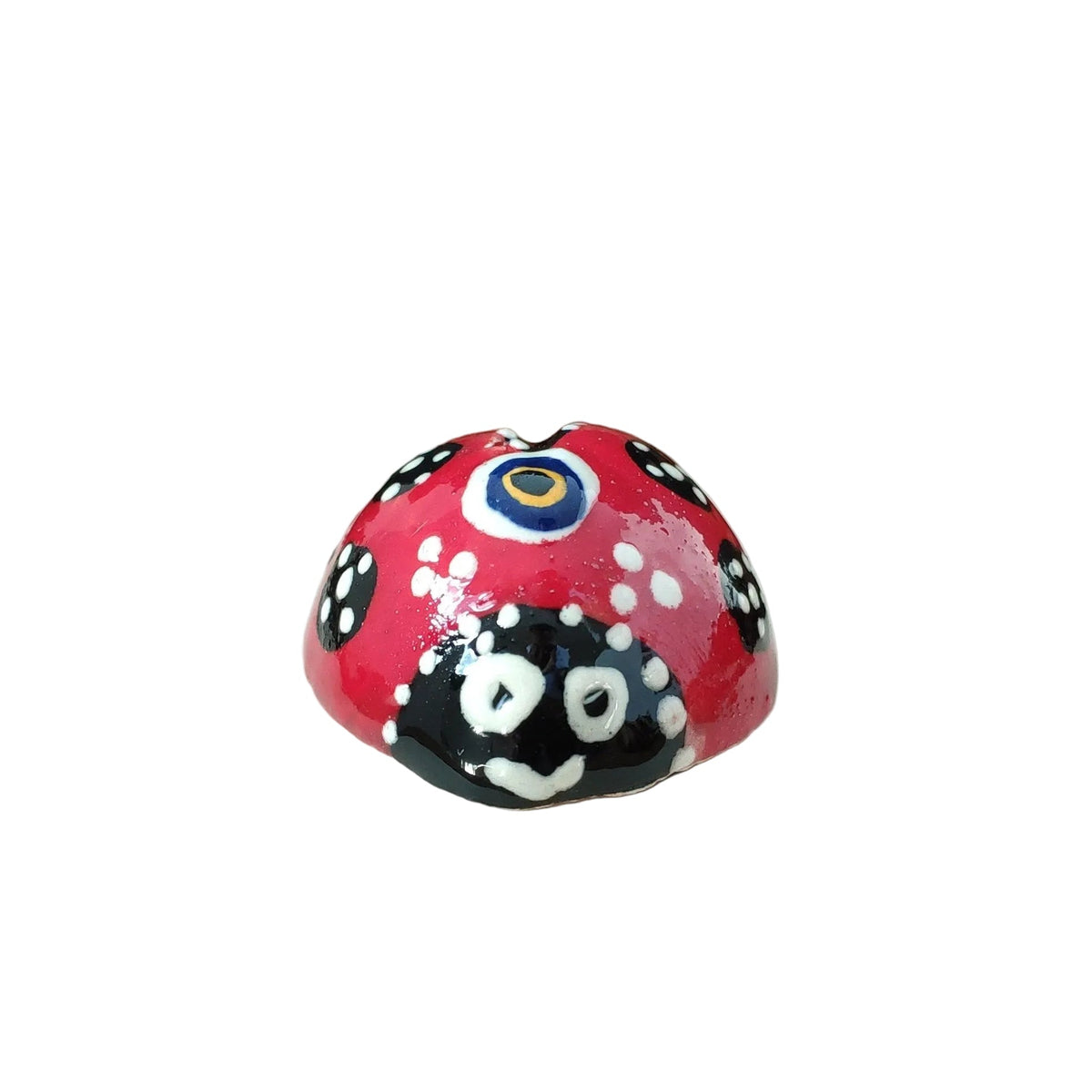 Decorative lady-bug shaped red ceramic fridge magnet with black and white patterns on a white background