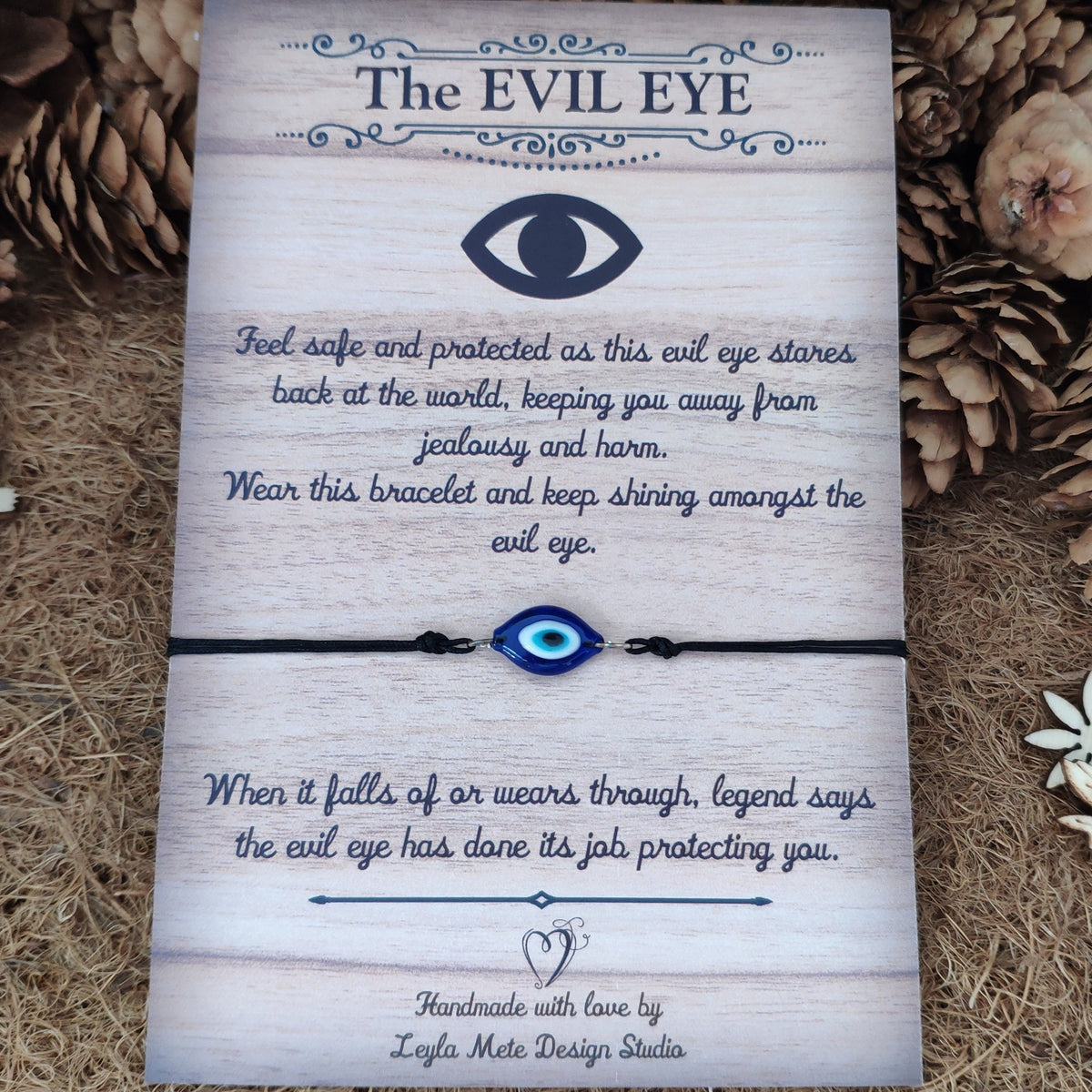 Evil eye bracelet on a brown card with text and decorative elements.