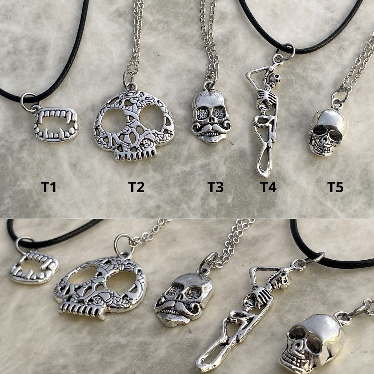Collection of silver skull necklaces on a textured surface