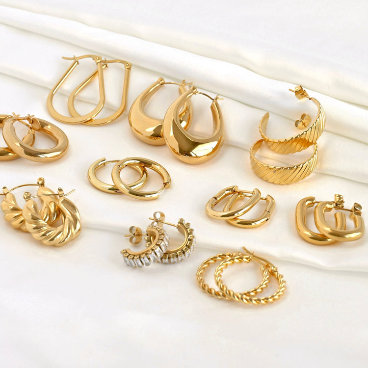 10 unique gold hoop earrings in stainless steel on white satin, ranging from everyday simplicity to striking bold or diamond designs.