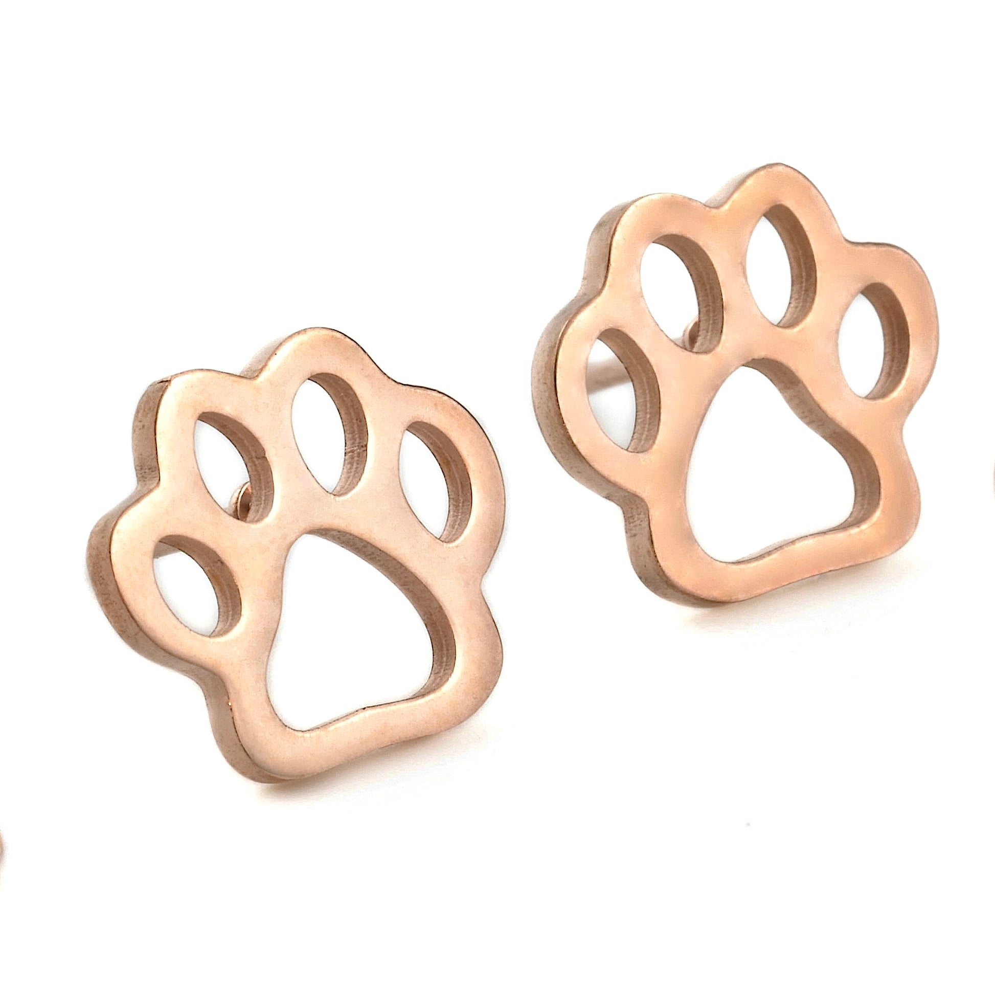 Rose gold paw print earrings on a white background