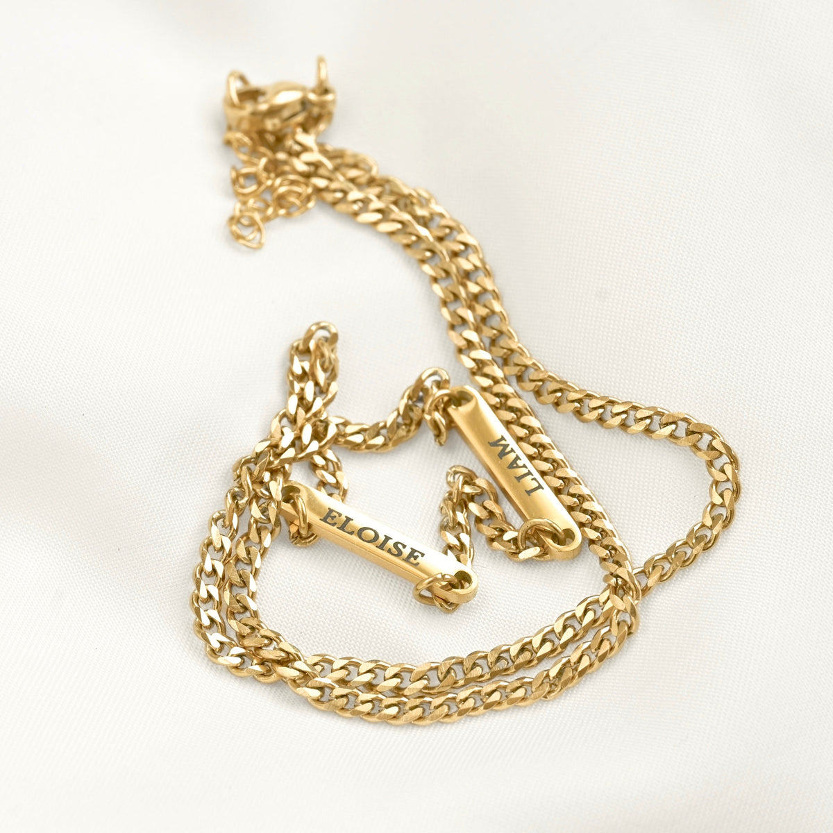 A gold-toned chain necklace with two bar charms engraved with the names 'ELOISE' and 'LIAM'.