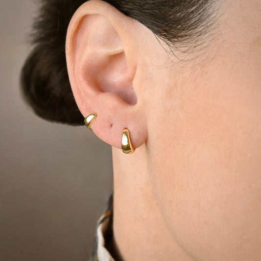 Gold bold huggie hoop earrings worn on an ear with size labels '6mm' and '8mm'.