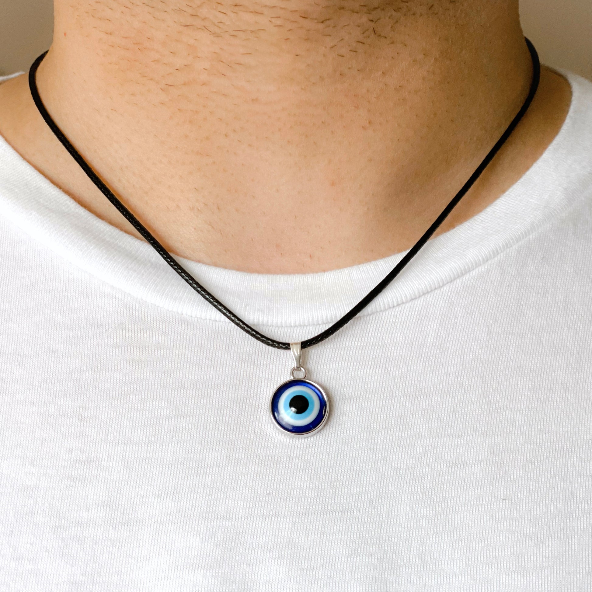 Necklace with an eye-shaped pendant worn by a person on a plain background