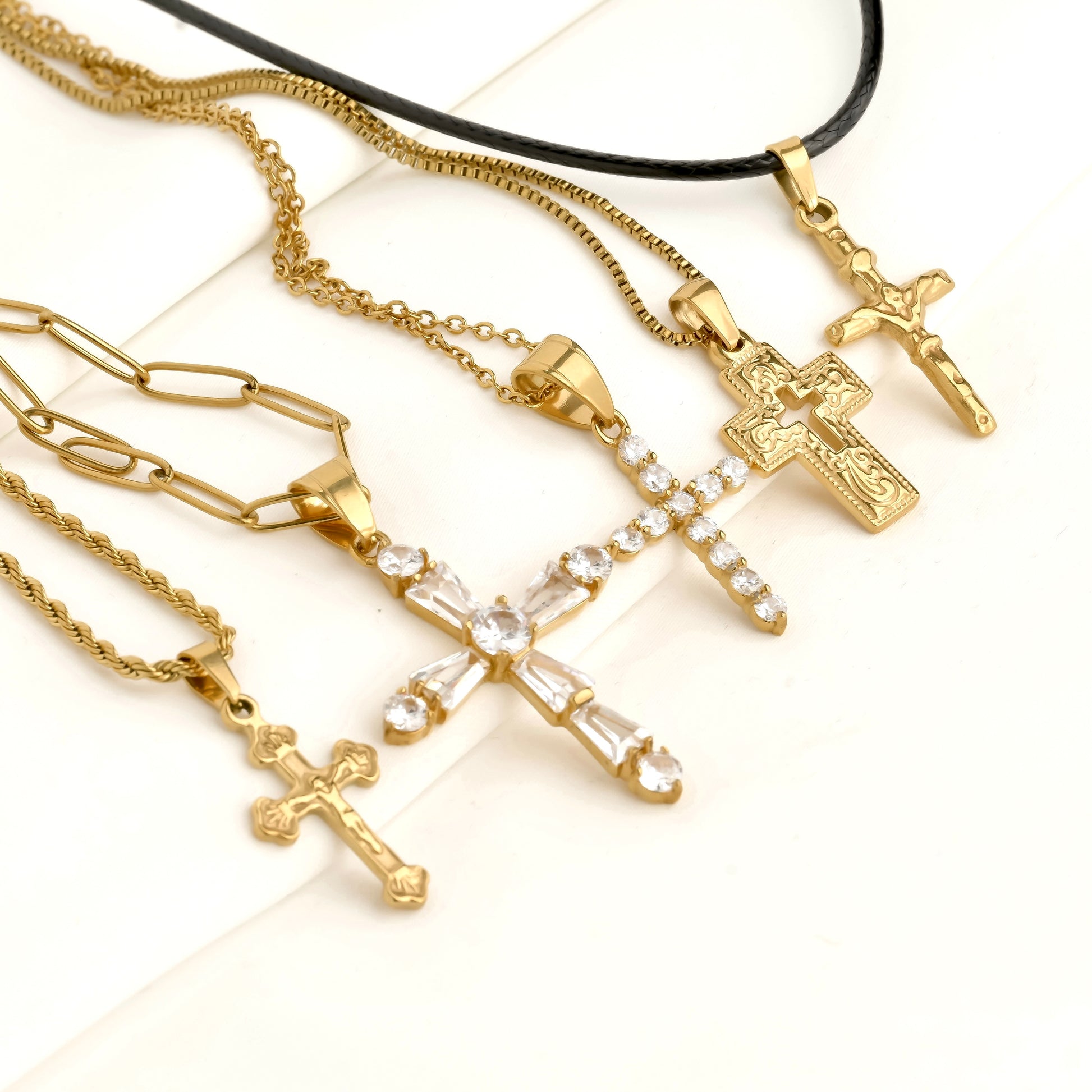 Gold necklaces with cross pendants on a white background