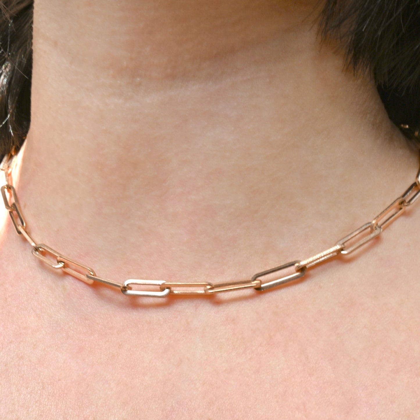 Bold Rose gold link chain necklace on a person's neck