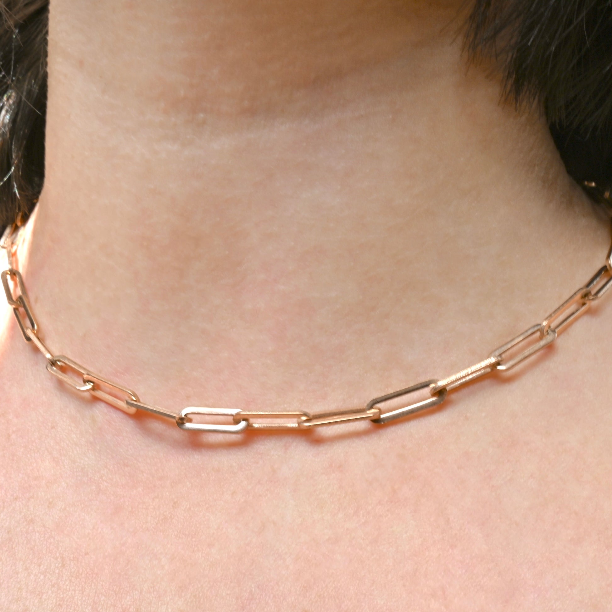 Bold Rose gold link chain necklace on a person's neck