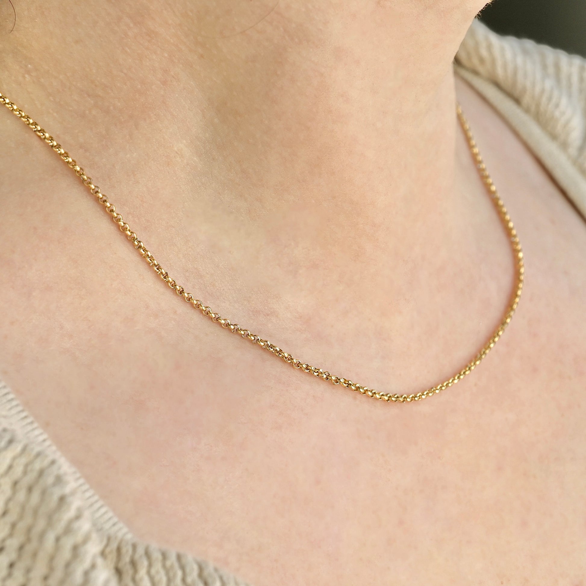 Side view of Gold rolo chain necklace on a person's neck 