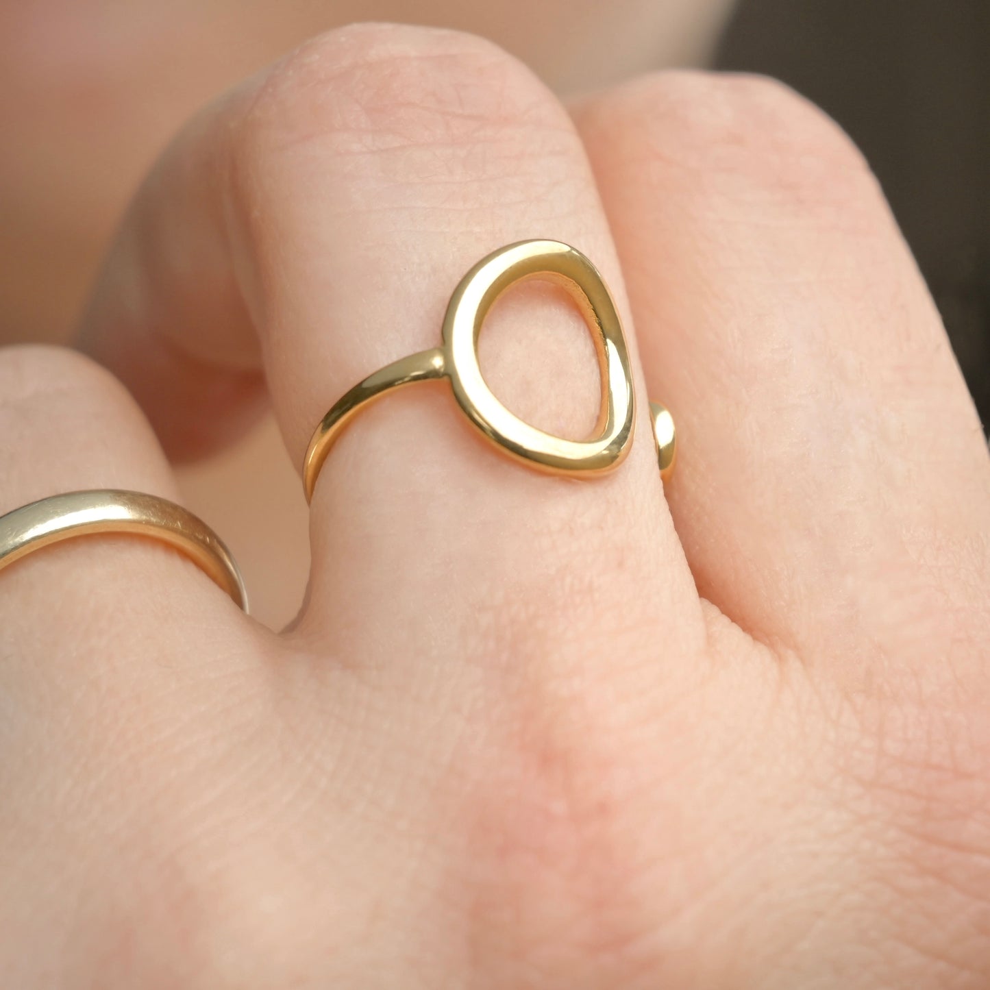 Gold circle ring on a finger with a blurred background