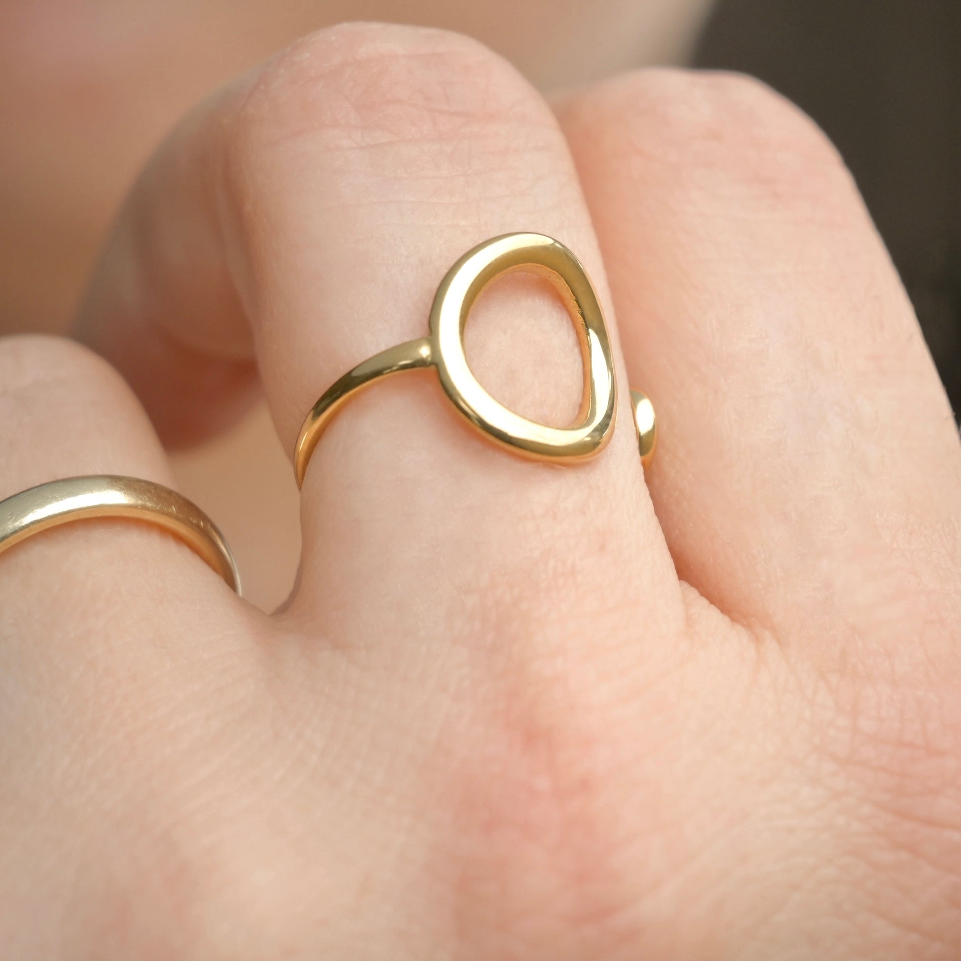 Gold circle ring on a finger with a blurred background