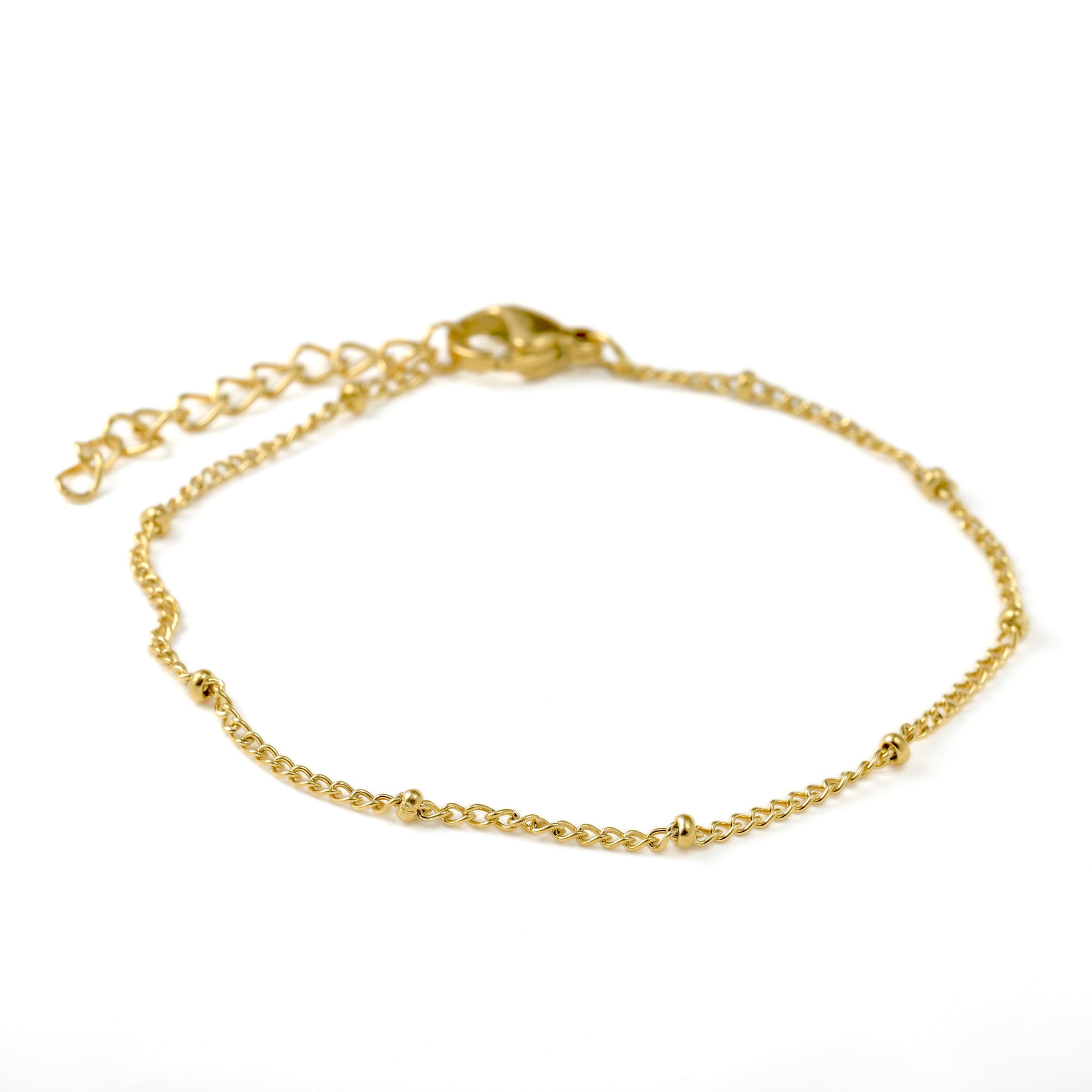 Front view of gold beaded satellite chain bracelet  with a lobster claw clasp and extender on a white background