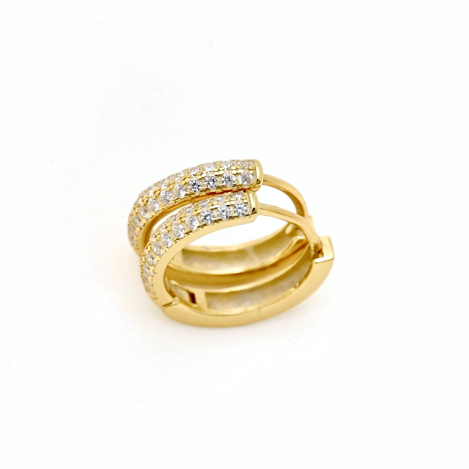 A gold huggie hoop earring adorned with pavé-set clear stones on the front band, photographed on a clean white background.