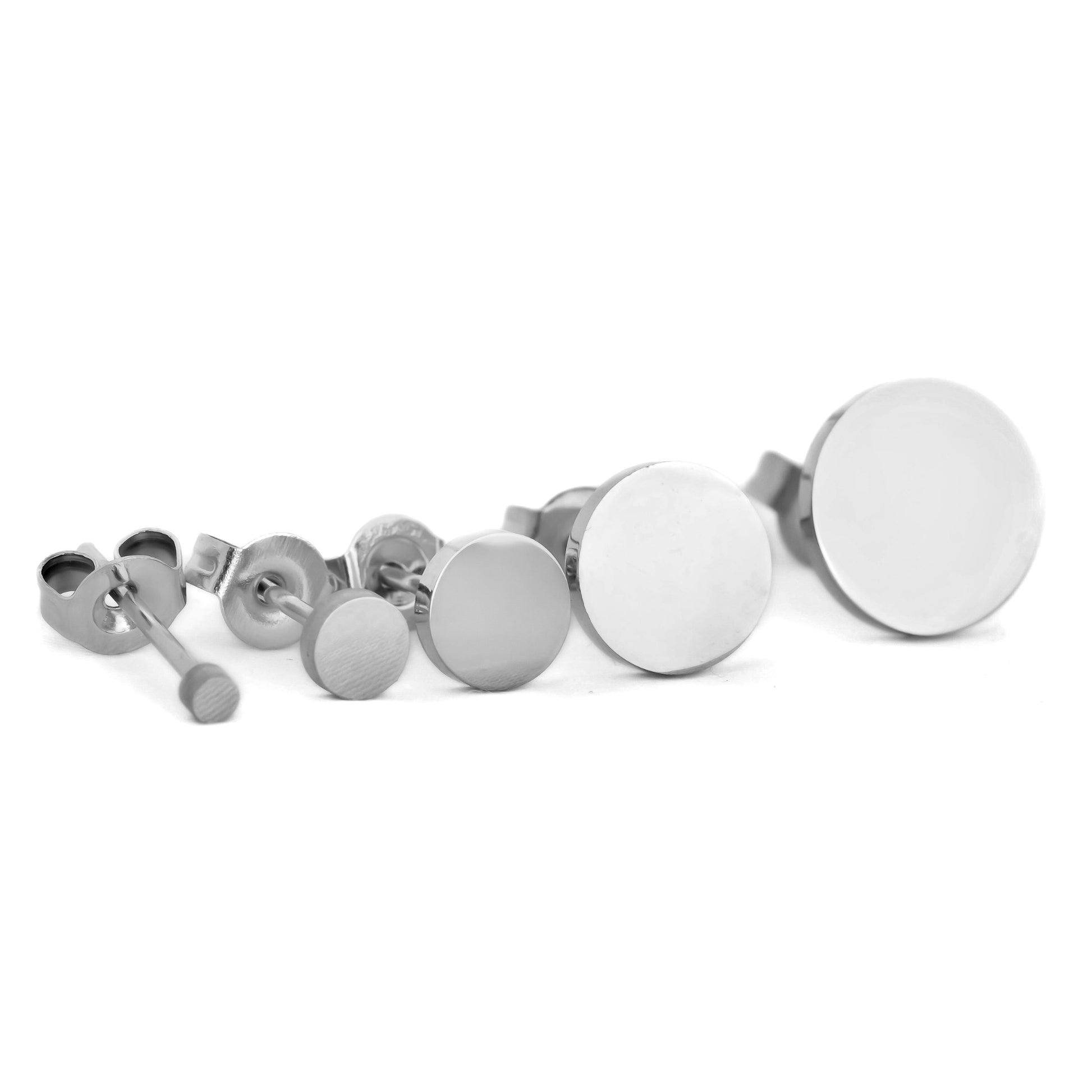 Set of silver disc studs on a white background arranged from small to bigger from left to right.