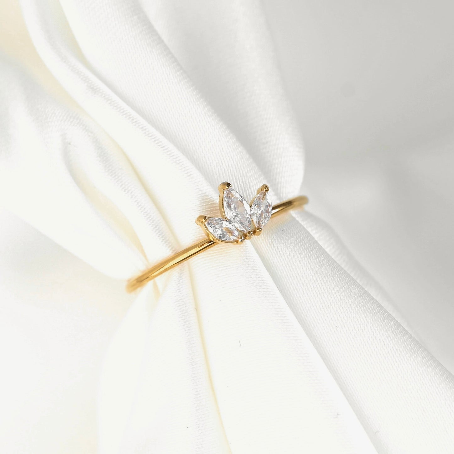Gold ring with a diamond on a white fabric background