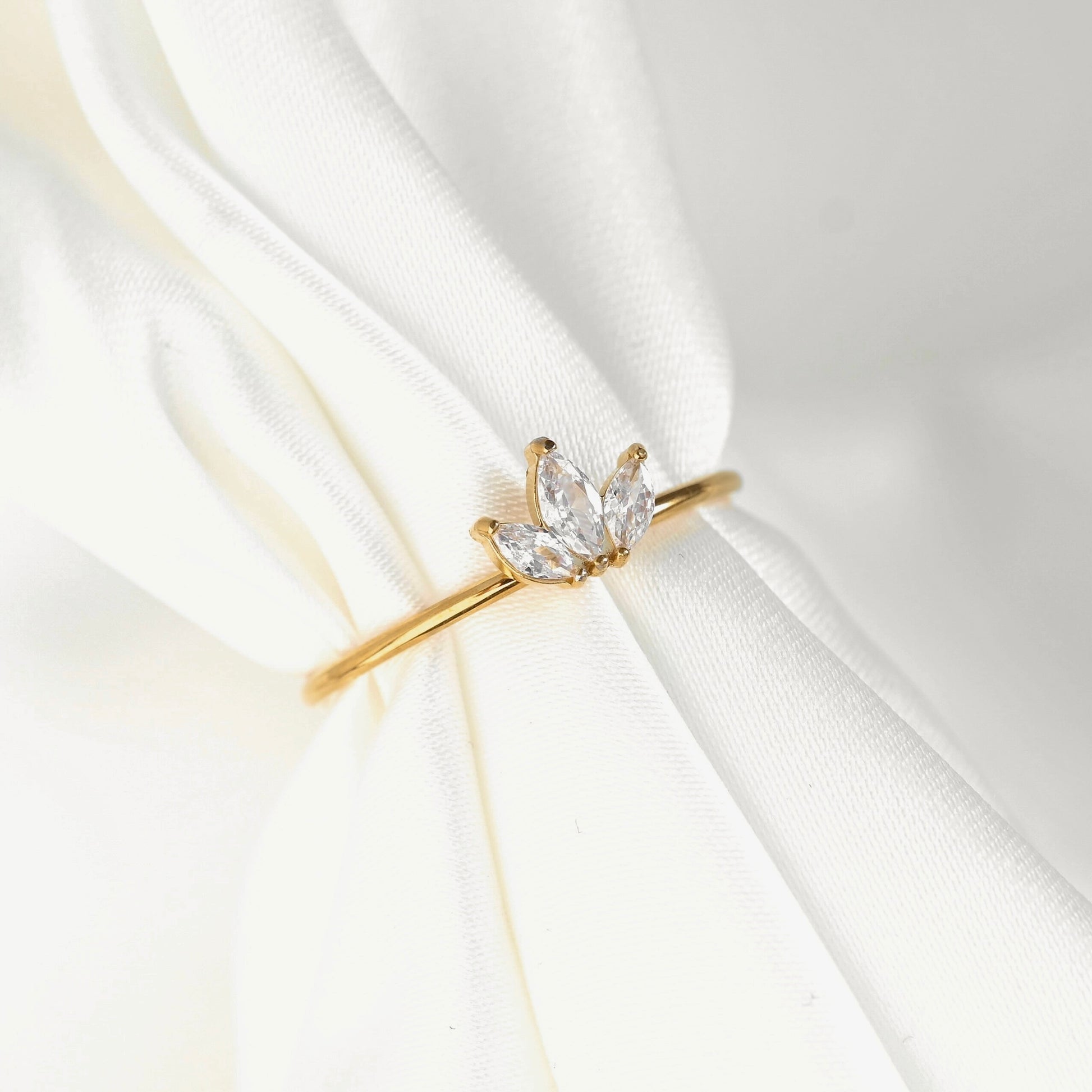 Gold ring with a diamond on a white fabric background