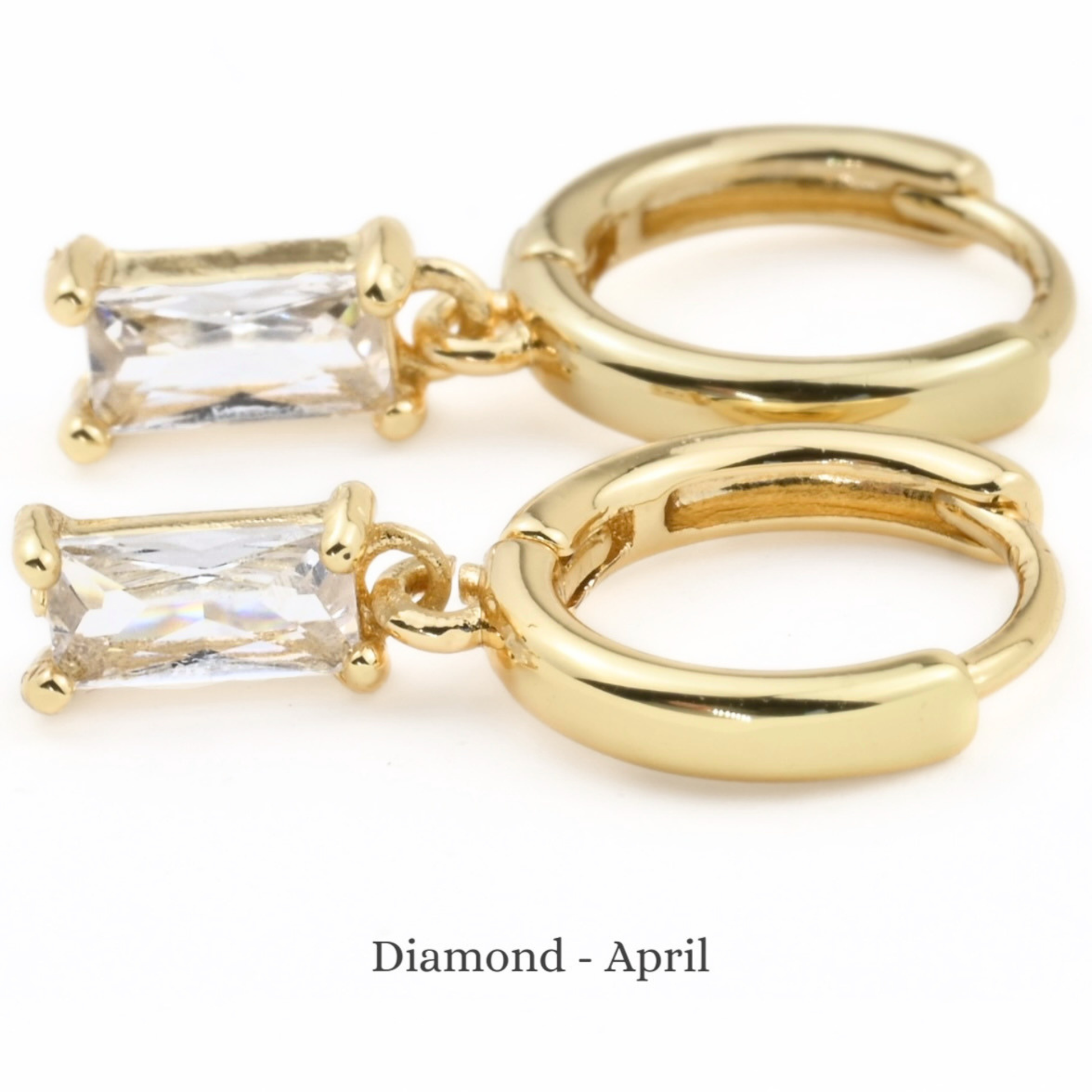 Baguette cut April birthstone charm hoop earrings on a white background