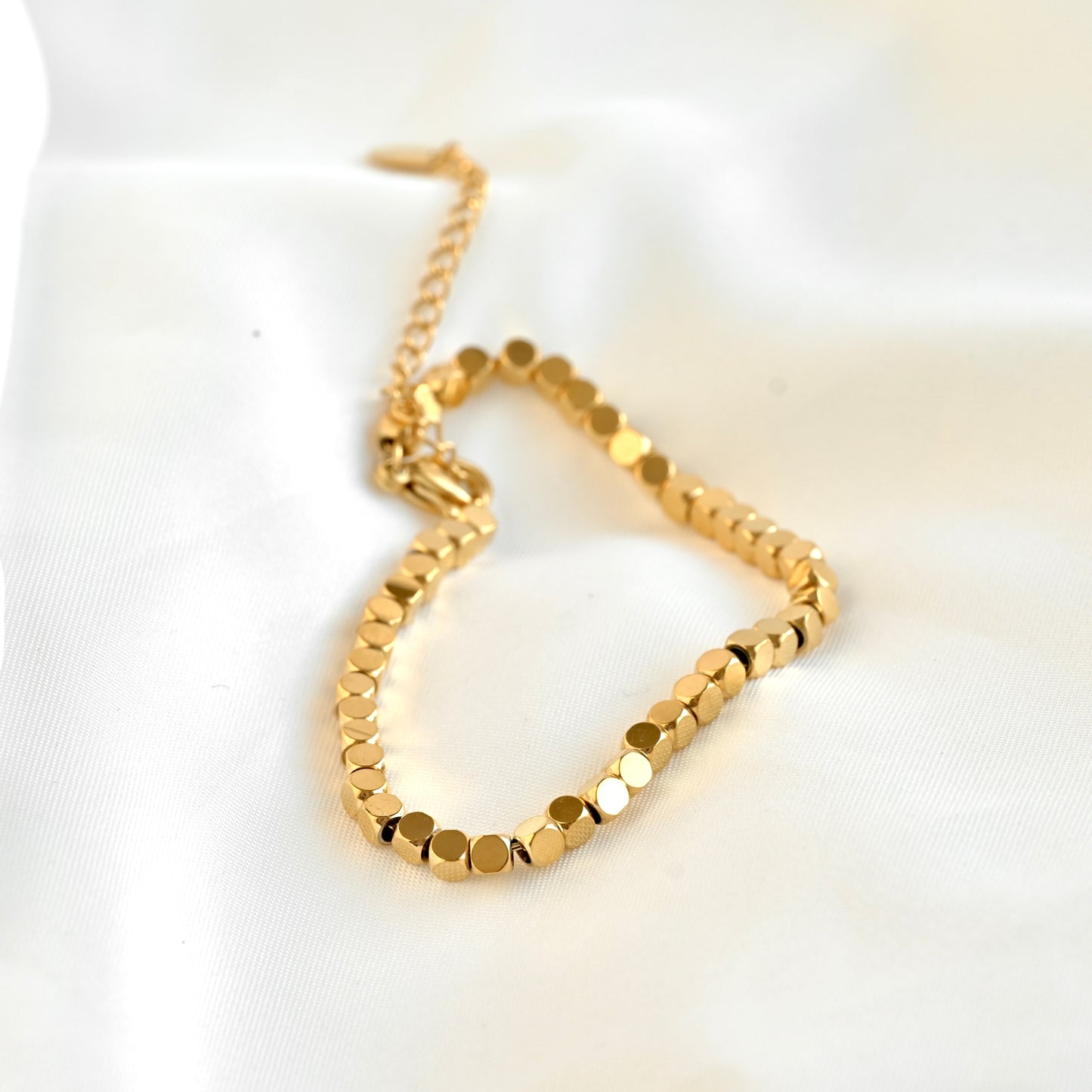 Gold cube chain bracelet on a white background