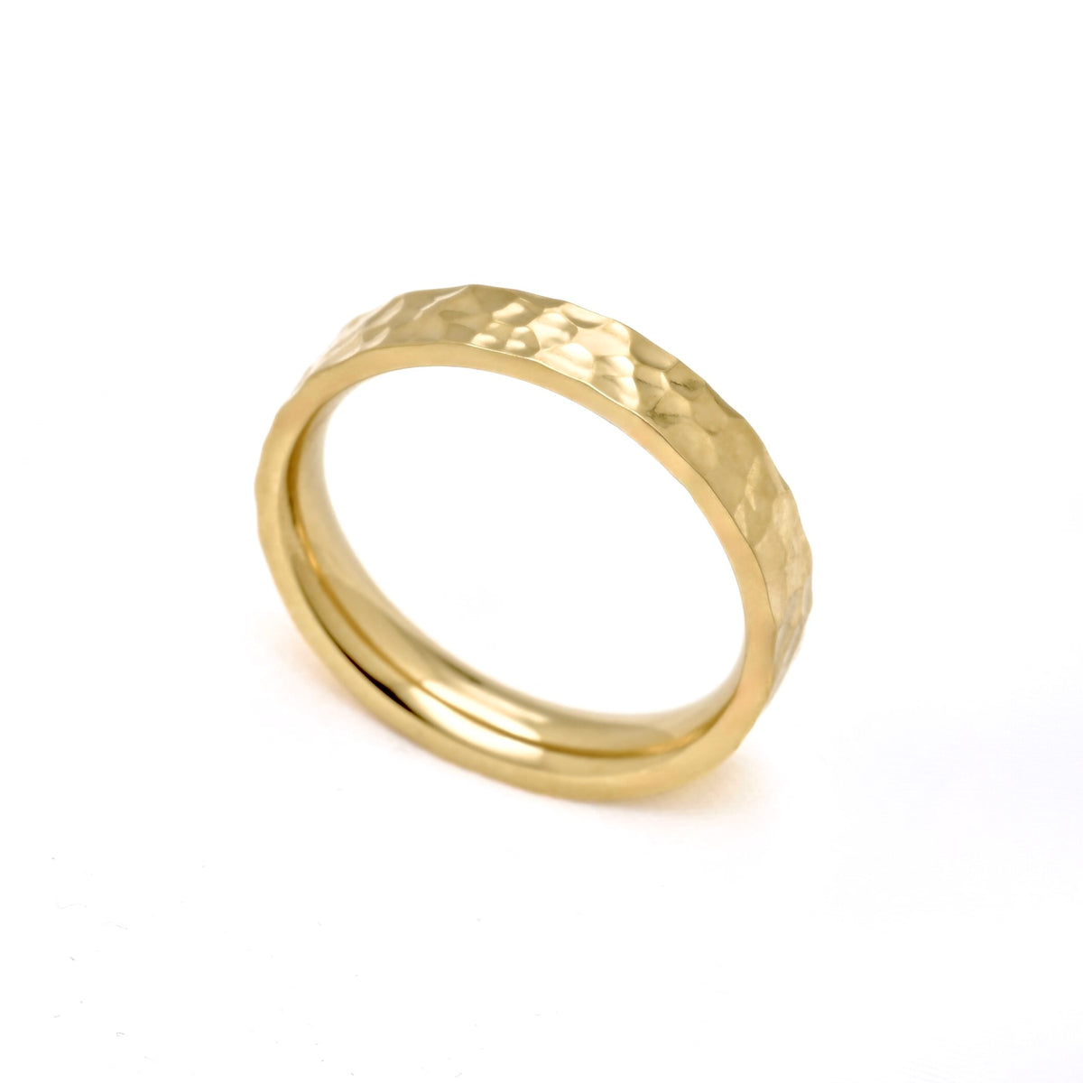 A gold band ring with a hammered textured exterior and a smooth polished interior, shown on a plain white background.
