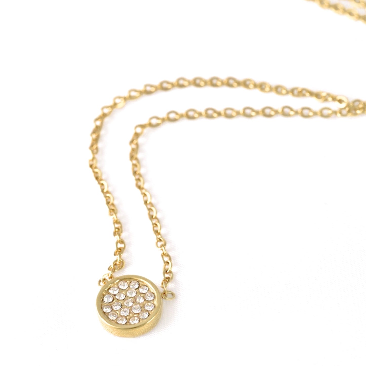 A gold chain necklace with a small round pavé pendant on a clean white background.