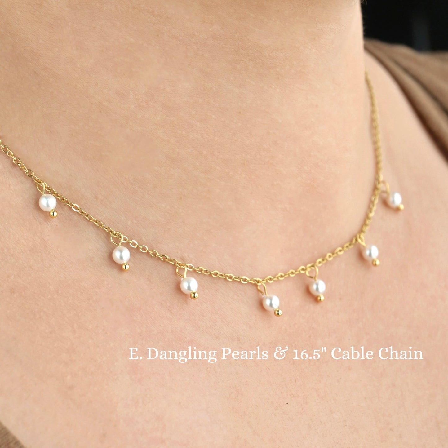 Gold necklace with dangling pearls on a person's neck