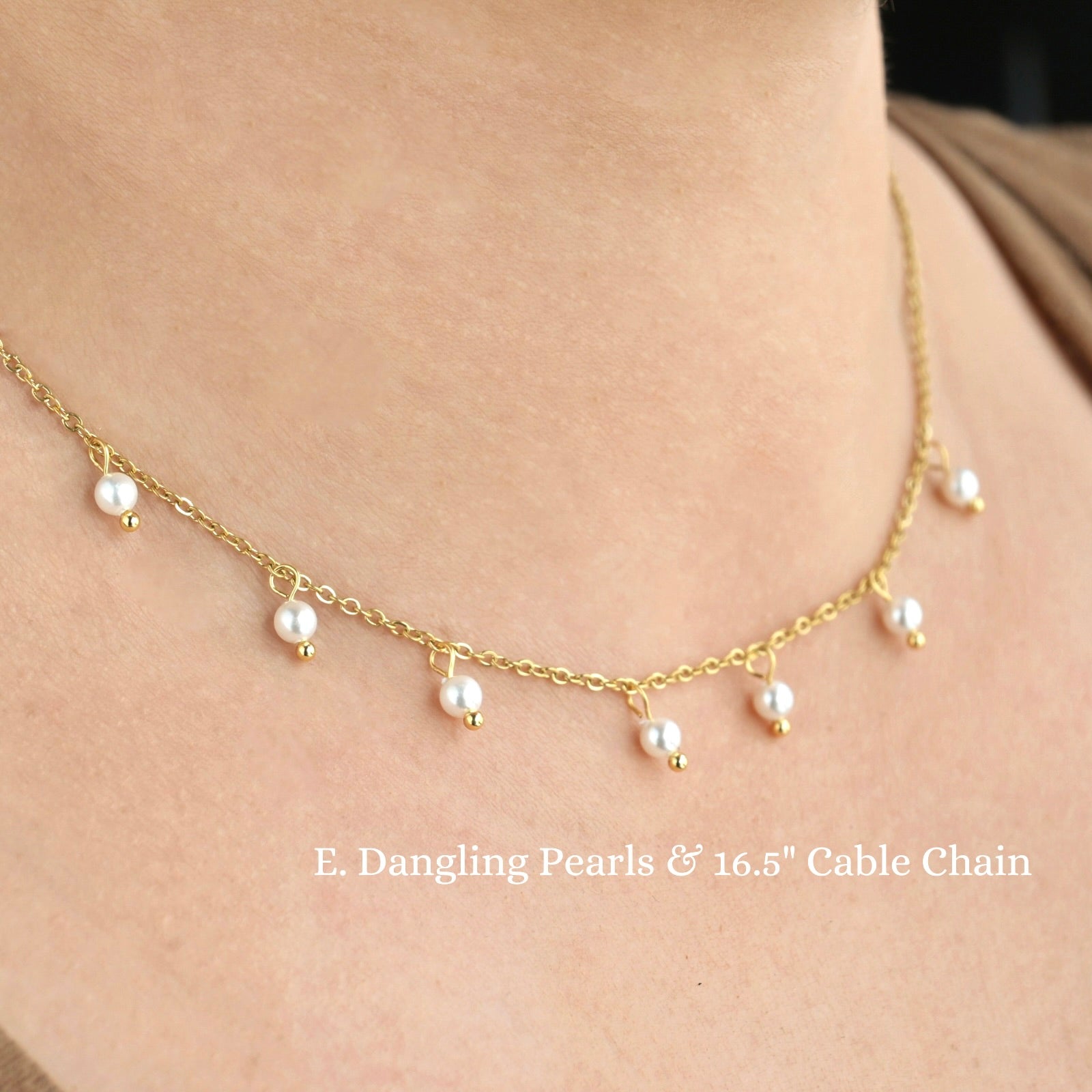 Gold necklace with dangling pearls on a person's neck