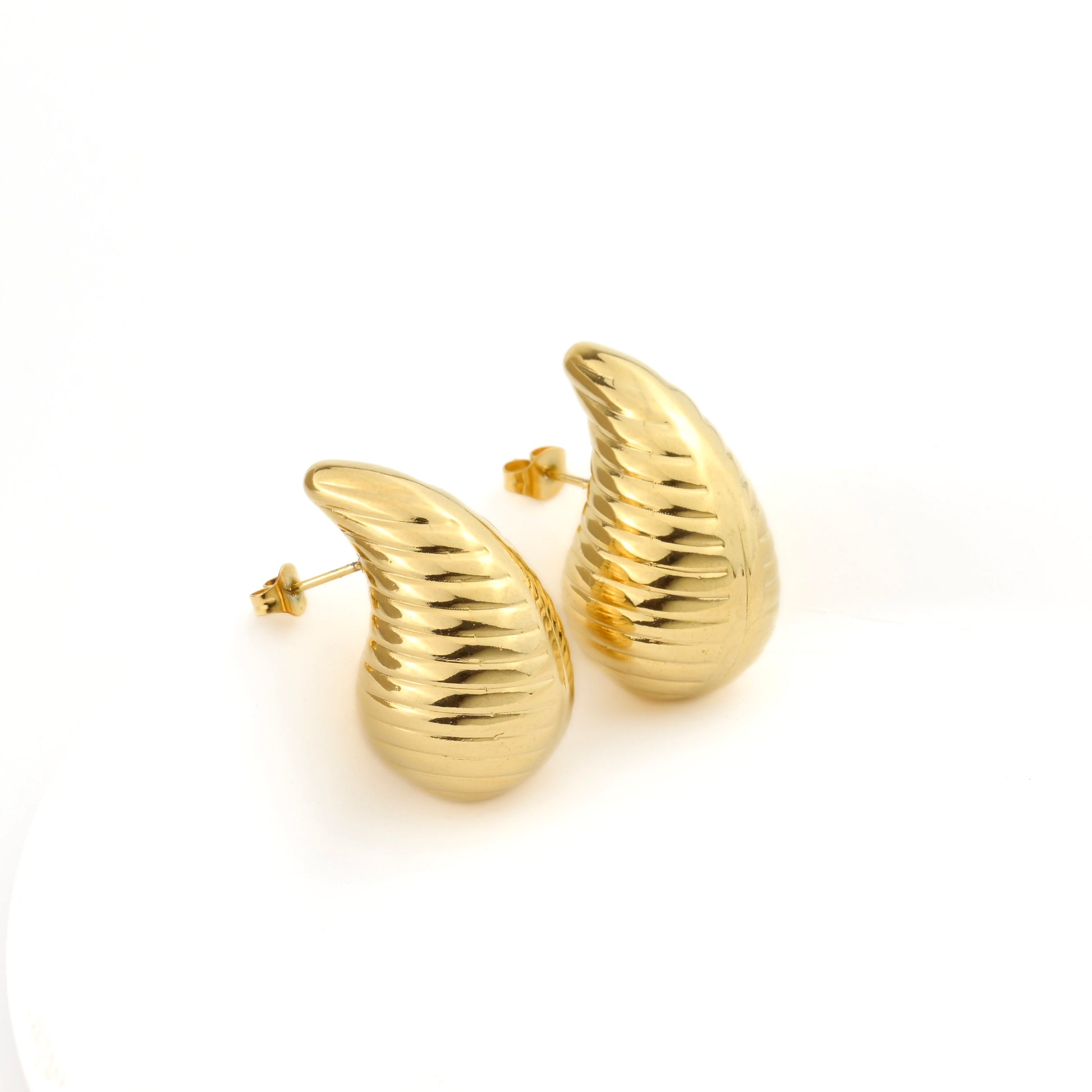 Gold cornucopia-shaped earrings on a white background