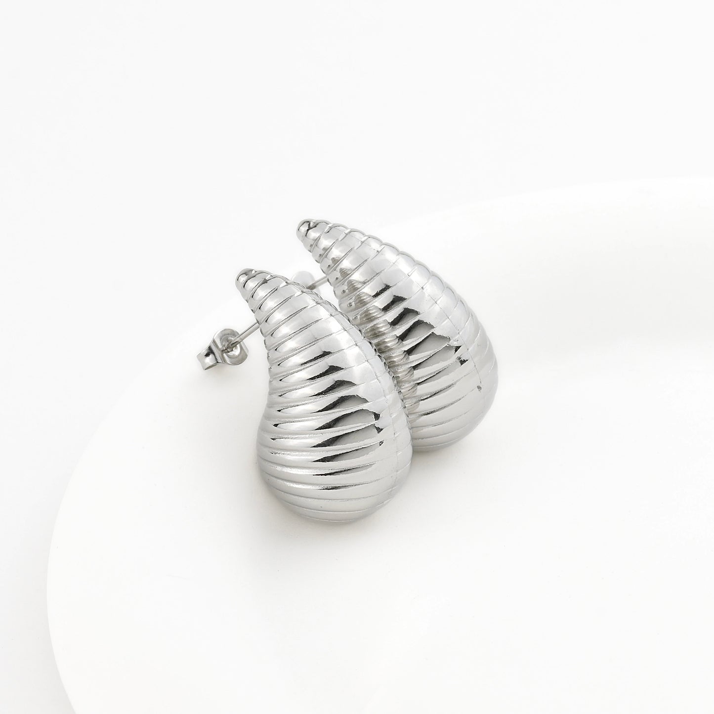 Chunky Silver shell-shaped earrings on a white background