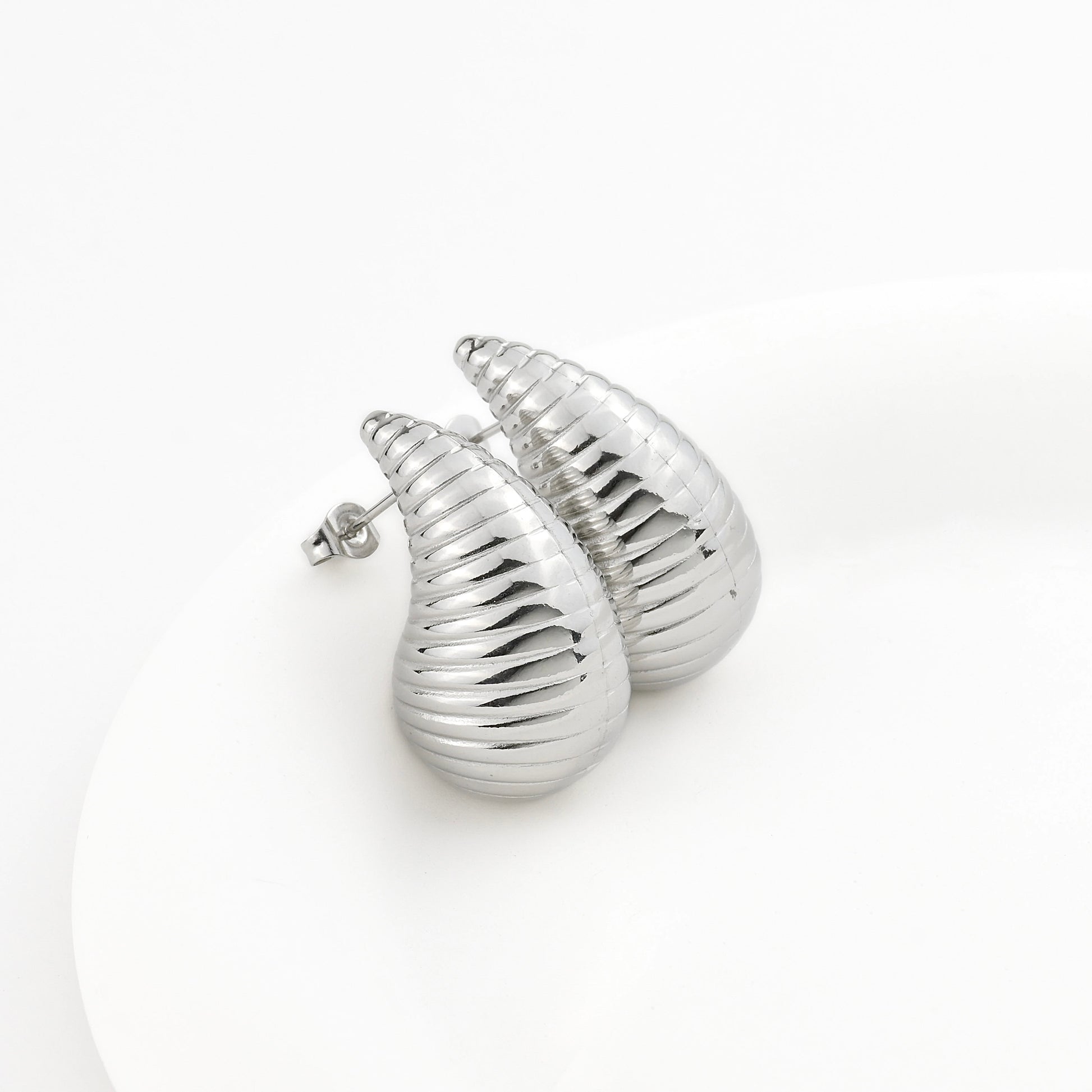 Silver shell-shaped earrings on a white background