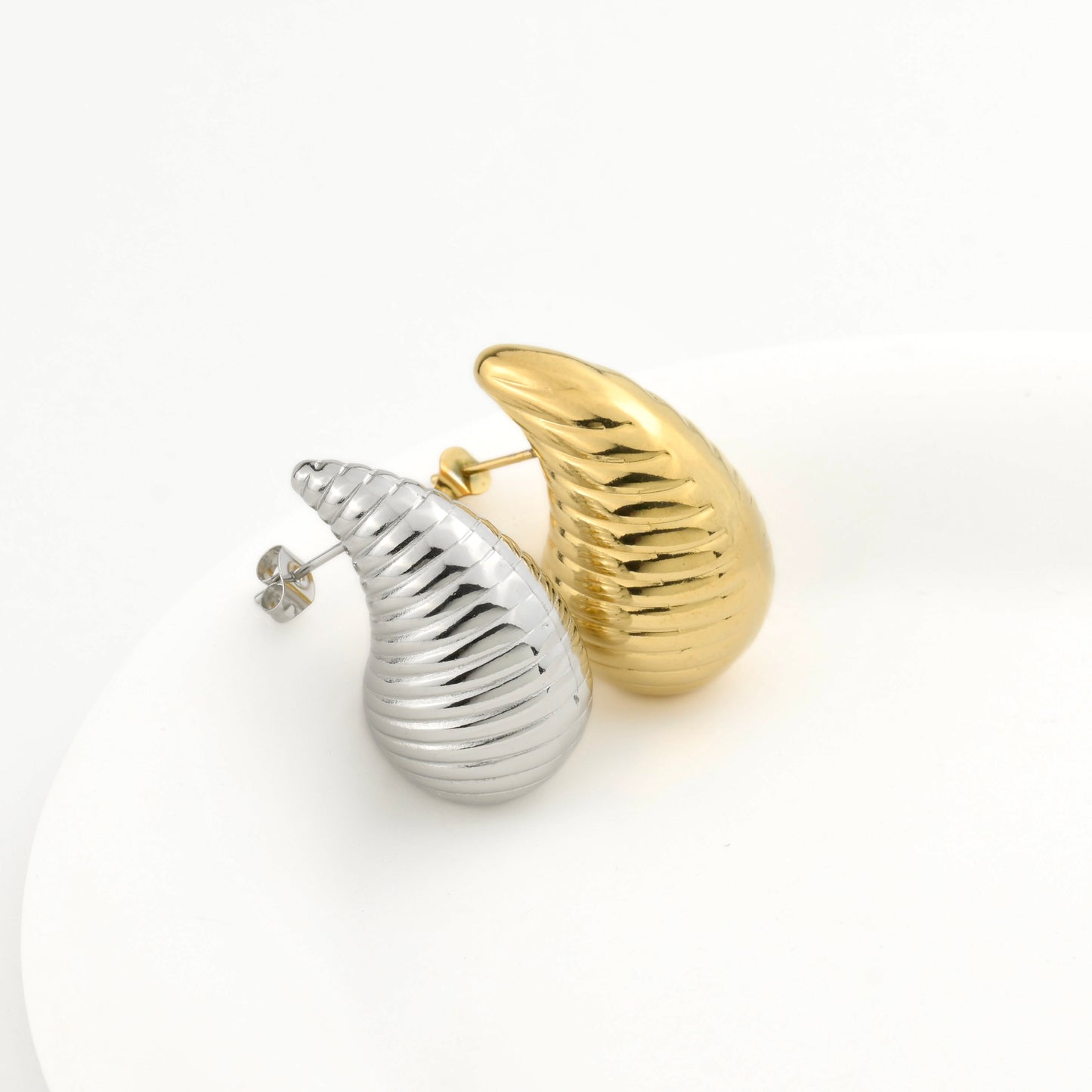 Gold and silver bottega inspired earrings on a white background