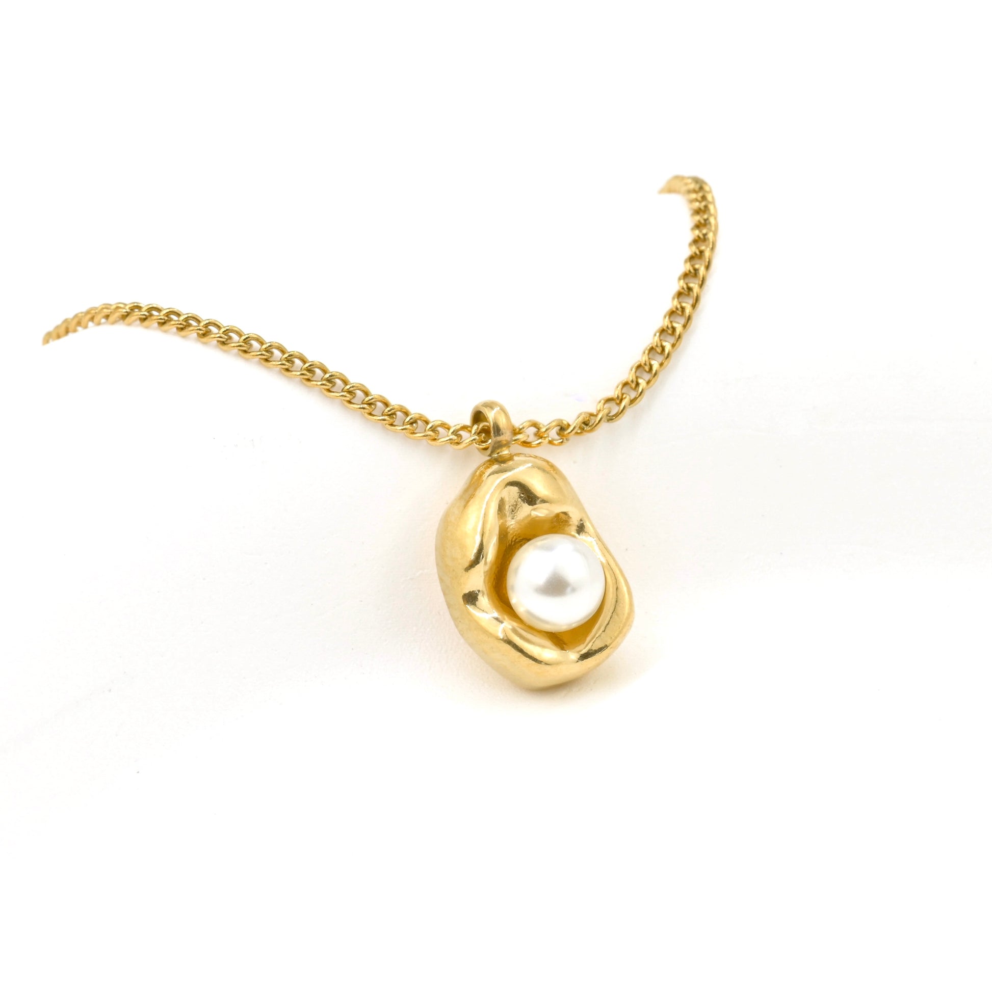 Close-up of gold necklace with a pearl pendant and thin curb chain on a white background