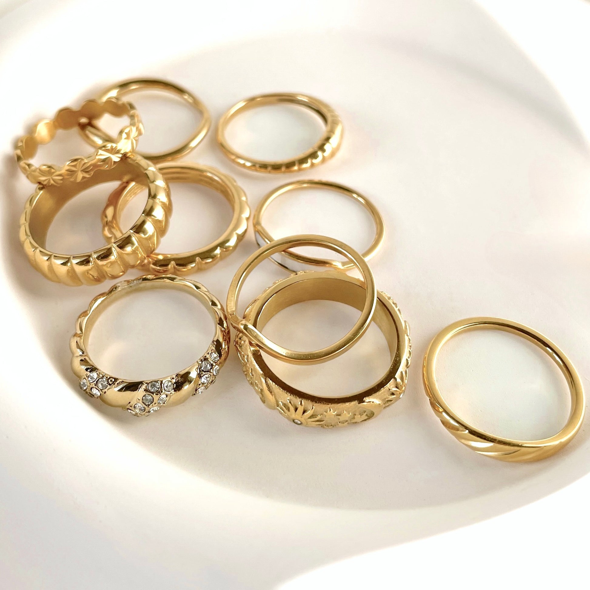 Collection of tarnish-free gold rings on a white plate