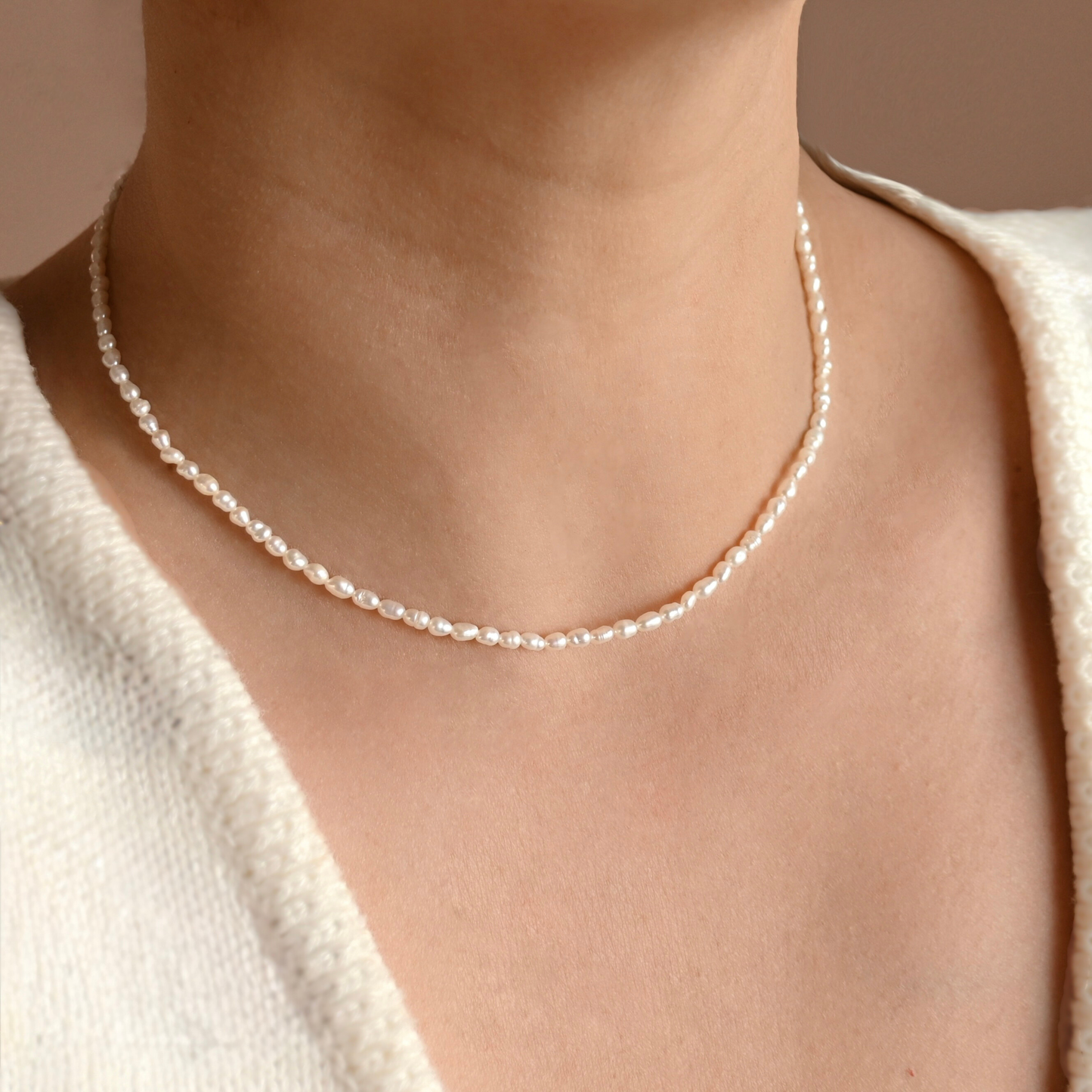 3mm rice pearl necklace worn by a person with a neutral background