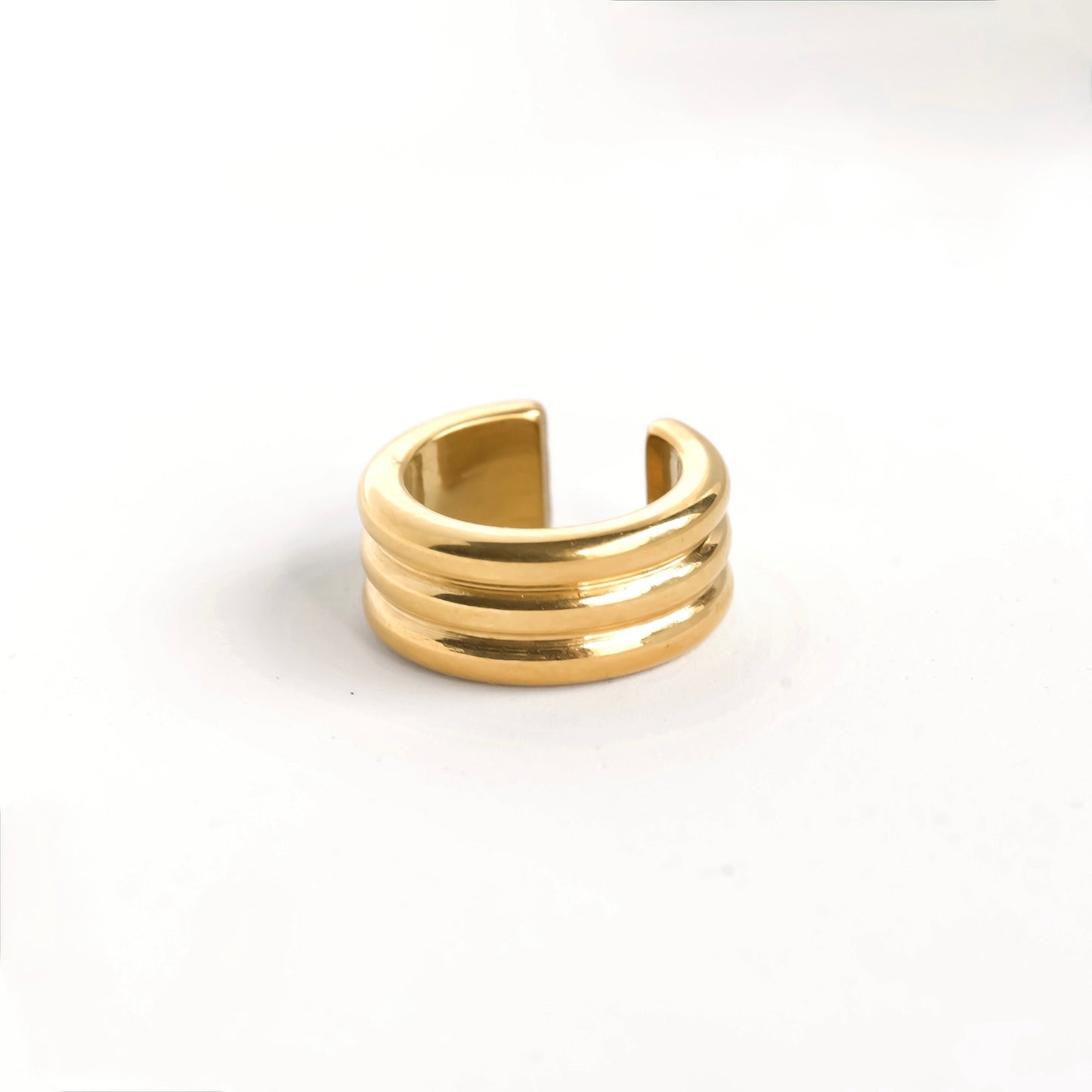 Chunky striped gold ear cuff on a white background