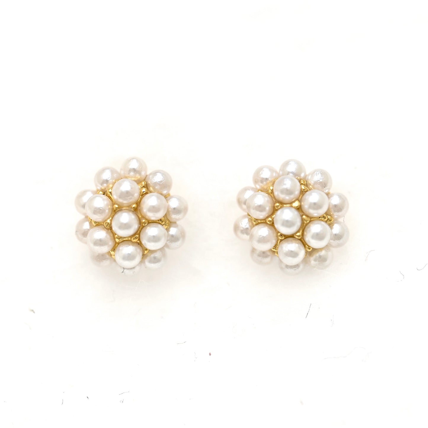 A pair of gold stud earrings featuring a cluster of small white faux pearls, photographed on a plain white background.