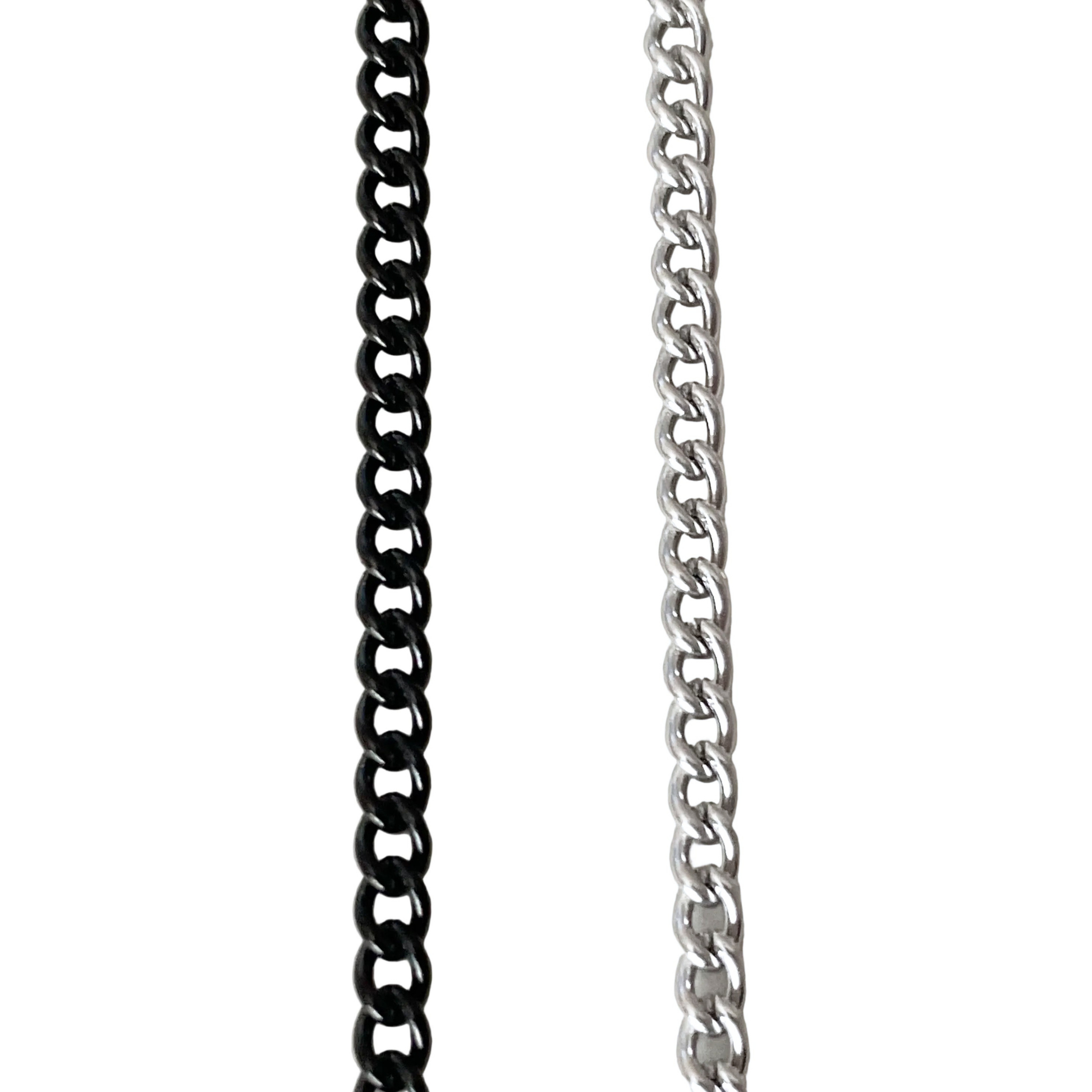 Close-up top view of two curb chain necklaces, one black and one silver, on a white background.