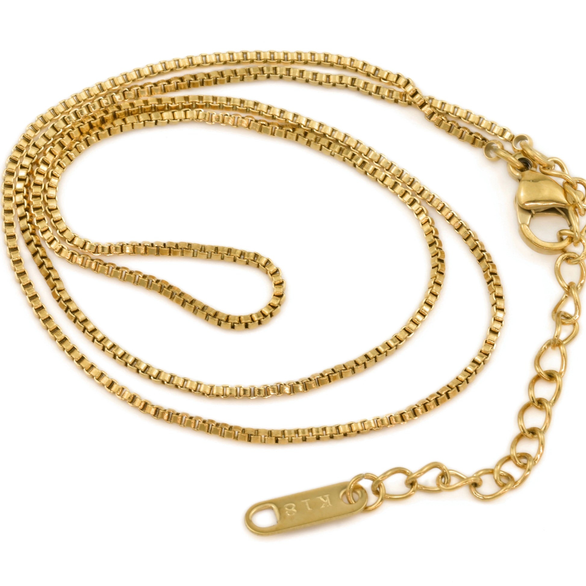 Gold venetian chain necklace with a lobster clasp and 'K18' plating stamped tag coiled on a white background
